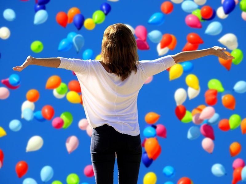 woman celebrating with balloons to beat the job search blues